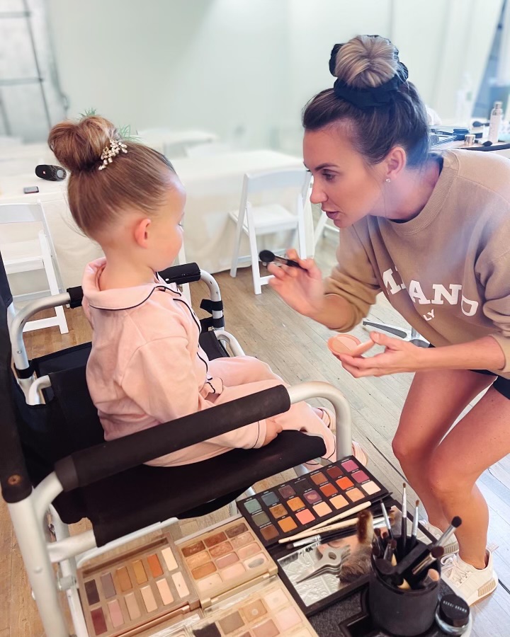 Laci doing makeup for a young girl at a community event